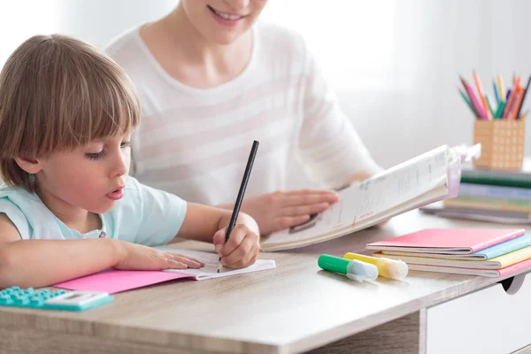 Junge Mit Adhd Macht Hausaufgaben Neben Lächelnder Mutter Mit Buch — Stockfoto
