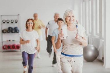 Yaşlı insanlar için fitness dersleri sırasında havlu egzersiz ile mutlu kadın kıdemli