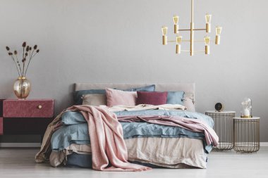 Pastel pembe ve bordo komidin yanındaki mavi ve bej yatak ve pembe yastık sıcak yatak DIY kadife üzerinde şık cam vazoda çiçekler kaplı