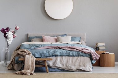 Trendy şık yatak odası iç mavi, rahat yatak ile gri duvar ayna yuvarlak pastel pembe ve bej çarşaf ve Kitaplar ile ahşap nightstands