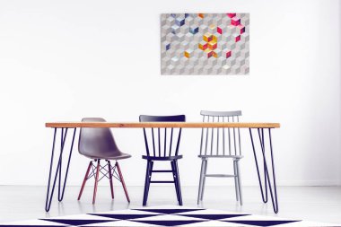 Beyaz boş duvar arkasında uzun ahşap masa sandalye ile geometrik grafik