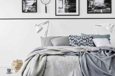King size Yataklı gri yatak ve beyaz lambalar, yığın kitap yerde fotoğraf toplayıcı yatak odası