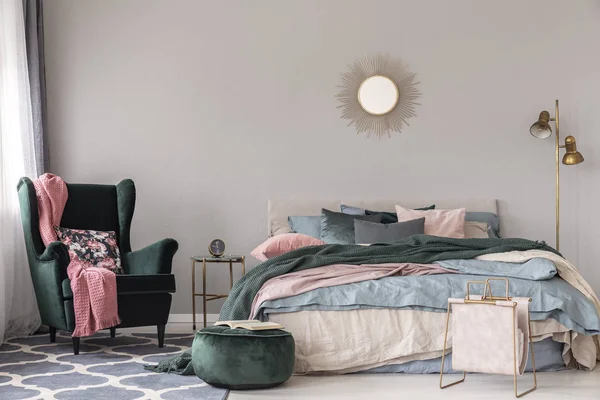 快適なベッドと現代的な寝室インテリアの空のコピー スペース グレーの壁に鏡のような太陽の形 — ストック写真