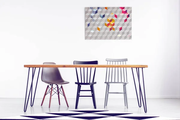 長い木製のテーブルと椅子の後ろに白い空の壁に幾何学的なグラフィック — ストック写真