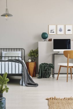 Ahşap komidin ve resepsiyon ile bilgisayar, kopya alanı boş gri Duvar ile gerçek fotoğraf yanında mavi yatak takımları ile tek kişilik metal yatak