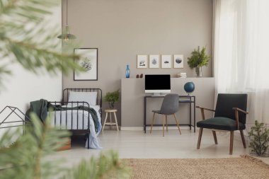 Orman ilham klasik koltuk trendy genç yatak odası, Resepsiyon bilgisayar ve ladin cam vazoda dalları ile