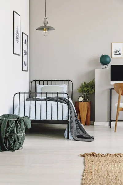 金属篮子与灰色毯子旁边的单人床与蓝色床上用品在时尚的卧室内部 真正的照片与复制空间 — 图库照片