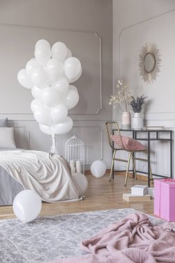 Son moda yatak odası tasarımı grup beyaz balonlar, altın sandalye ve ayna ve pembe malzeme ile şık şifonyer ile dikey görünüm yerde