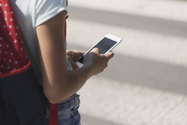 Bir çocukla yaya geçidi yürürken bir akıllı telefon yakın çekim