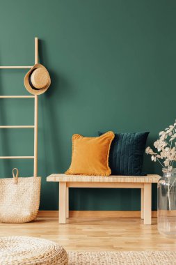 Kopya alanı boş yeşil duvar ile doğal tasarlanmış iç, gerçek fotoğraf ahşap sehpa üzerinde sarı ve zümrüt yastık