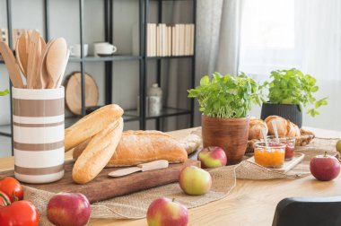 Elma, baget ekmek ve fesleğen kaşık parlak yemek odası iç ahşap tablo. Gerçek fotoğraf