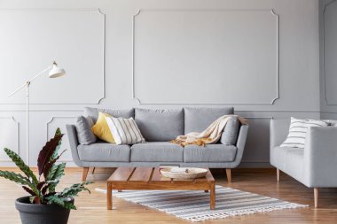 Ahşap sehpa gri oturma odası kanepe ve kopya alanı boş duvara, gerçek bir fotoğraf ile ortasında