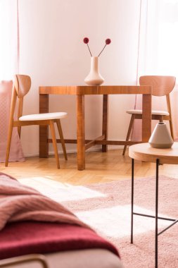 Çiçekli pembe halı ile parlak daire iç ahşap masa sandalyeler. Gerçek fotoğraf