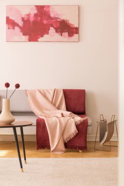 Pastel pembe ve bordo battaniye ile gri kanepe ile zarif oturma odası boş beyaz duvardaki soyut resim