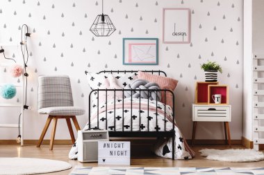 Beyaz ahşap merdiven ve endüstriyel metal tek kişilik yatak ile siyah beyaz yatak ve gri ve pastel pembe yastık arasındaki gri sandalye