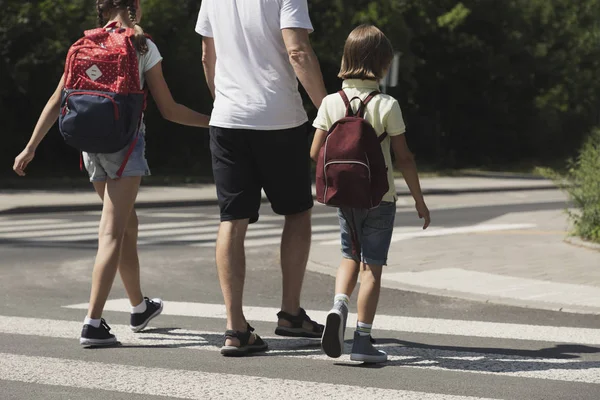学校から帰ってきて 彼の子供たちと通りを横断の父 — ストック写真