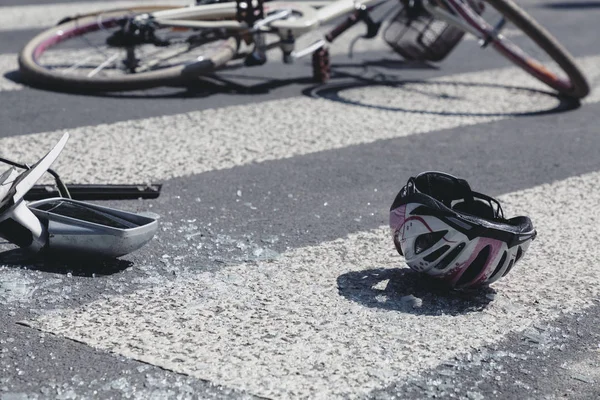 Child's helmet and car's mirror on a pedestrian crossing after collision with a bike