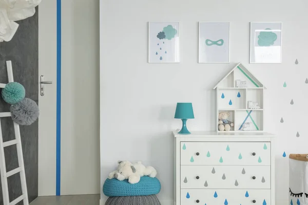柜子上方的海报 白色儿童房间内部有蓝色的灯 普夫身上有毛绒玩具 真实照片 — 图库照片