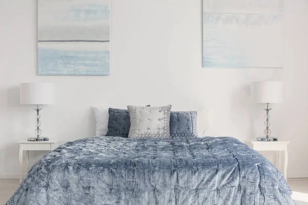 Cama Azul Com Travesseiros Entre Lâmpadas Mesas Interior Quarto Branco — Fotografia de Stock