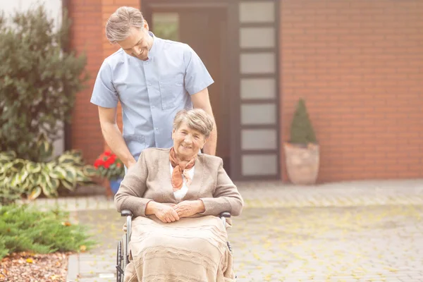 Leende Stilig Male Sjuksköterska Och Senior Pensionär Rullstolen Trädgården Sjukhem — Stockfoto