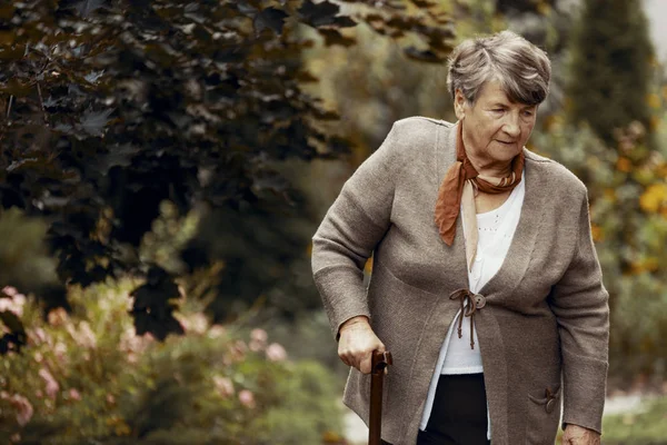 Parkta yürüyüş baston ile üst düzey kadın