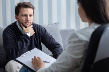 Danışmanla son psikoterapi seansında kendinden emin genç ve yakışıklı bir adam.