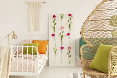 Boho stil, çiçek kurulu ve makrome duvar, tavus kuşu sandalye köşedeki tasarlanmış kızın yatak