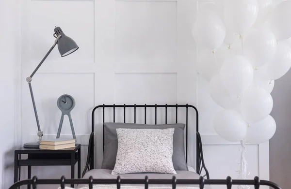 Sekelompok Balon Putih Sebelah Satu Tempat Tidur Logam Hitam Dengan — Stok Foto