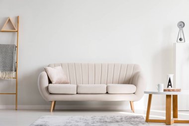 Ahşap sehpa ile kupalar, kopya alanı boş duvar yanındaki beyaz kanepe yastık