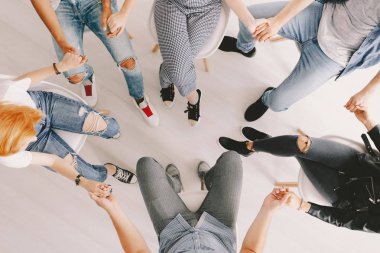 Grup psikoterapi oturum sırasında elele insan üstten görünüm