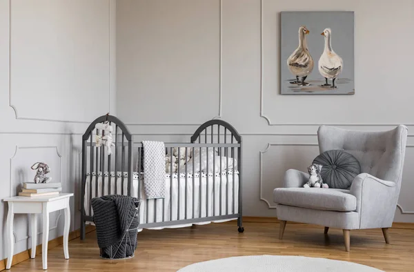 Stilvolles Graues Babyzimmer Mit Holzbett Bequemem Sessel Und Weißem Tisch — Stockfoto