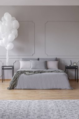 Şık yatak odası ile yatak ve siyah ahşap nightstands kopya alanı boş gri duvar