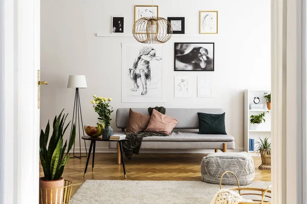 Posterler gri kanepe yastık aydınlık oturma odası iç ile masaya çiçek ile yukarıda. Gerçek fotoğraf