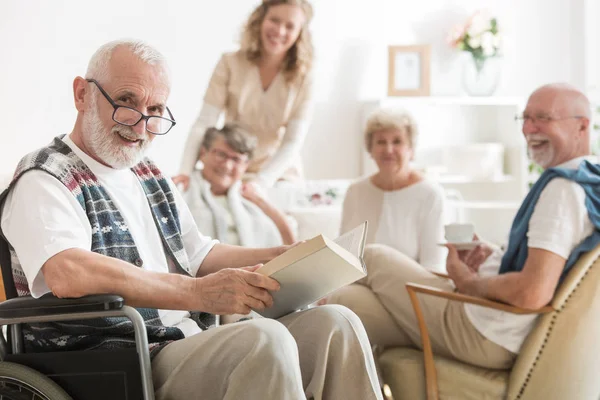 Yaşlı Adam Bir Kitap Okuma Tekerlekli Sandalye Üzerinde Oturan Gözlüklü — Stok fotoğraf