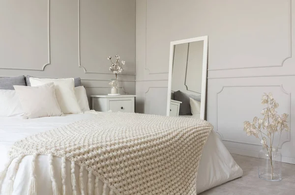 灰色の壁とおしゃれな寝室のインテリアにキングサイズのベッドの白いベッドにベージュのウール毛布 — ストック写真