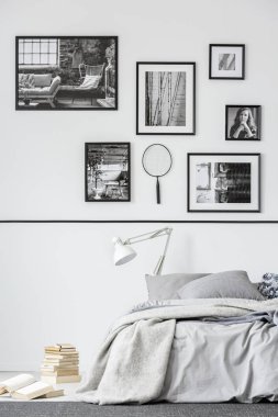 Kitap yanındaki gri yatak odası iç Fotoğraf Galerisi ile beyaz lamba ile yatak. Gerçek fotoğraf