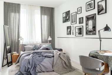 Parlak gri yatak odası iç pencere ve Fotoğraf Galerisi ile yatakta yanında ayna. Gerçek fotoğraf
