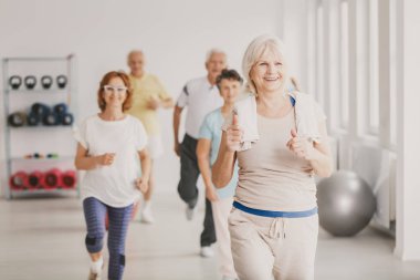 Gülümseyen kıdemli fitness talimat aktif yaşlılar grubuyla egzersiz