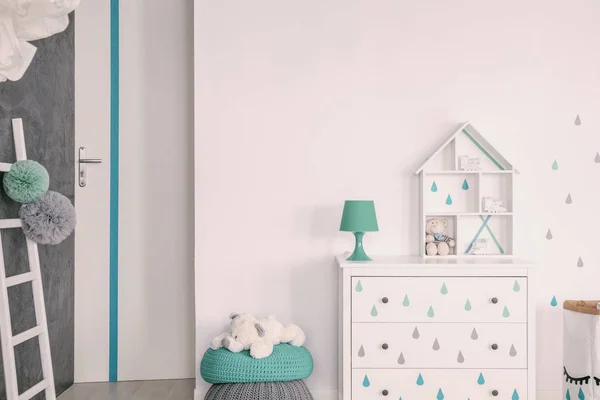 在柜子上的绿色灯旁边的毛绒玩具在白色的孩子的房间内部与梯子 真实照片 — 图库照片
