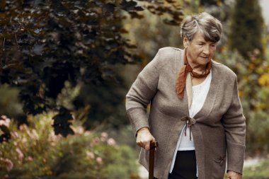 Parkta yürüyüş baston ile üst düzey kadın