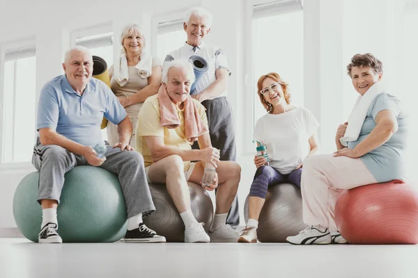 Grupa Aktywnych Seniorów Siedzi Ćwiczenia Piłki Nowoczesnym Centrum Fitness Treningu — Zdjęcie stockowe