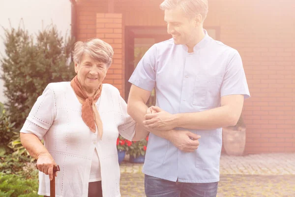 Mosolyogva Idősebb Nőt Walking Stick Sétálni Hasznos Férfi Ápoló — Stock Fotó