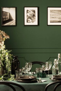 Classy dining room table with black plates, wine glasses and green plants