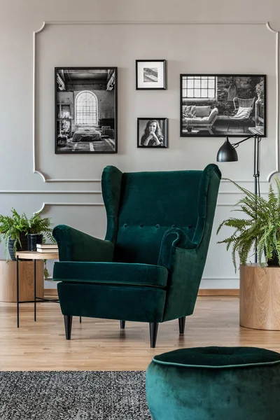 翡翠绿色扶手椅和 Pouf 在灰色的客厅内部与木制家具和黑色和白色的照片在墙上 — 图库照片