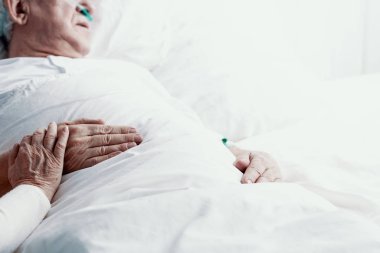 Form pankreas kanseri acı, hastane yatağında, yardım ve destek, sembolü olarak elinde fotoğraf kopya alanı ile döşeme yaşlı adam