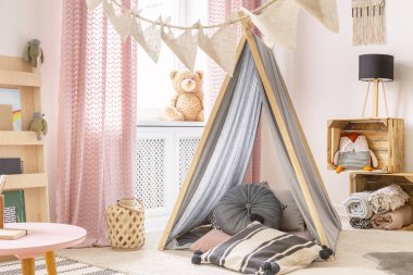 Real photo of a tent and pillows in a kid's room interior