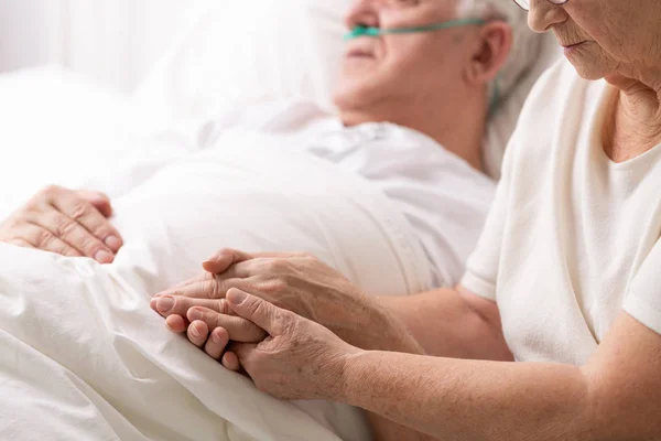 Старша Бабуся Тримає Руку Хворого Чоловіка Лежить Білому Ліжку Хоспісі — стокове фото