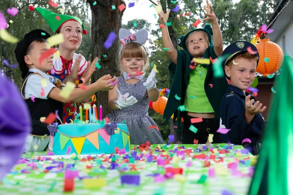 孩子们在花园里举行生日化妆派对时享受五彩纸屑的雨 — 图库照片