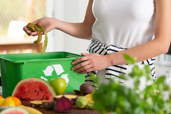 Vrouw Gooien Kiwi Schillen Een Groene Recycling Mand — Stockfoto