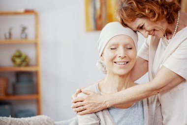 Üst düzey Kızıl saçlı kadın onun arkadaşı lösemiden acı çeken birine sarılma